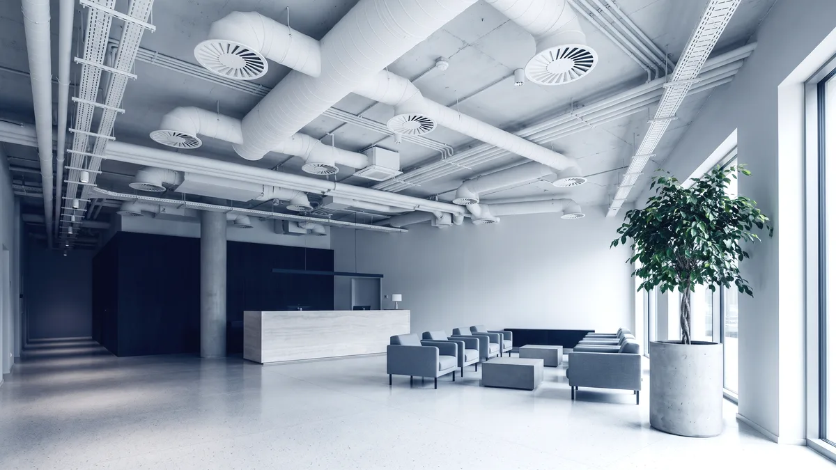 Helle Hotellobby mit Tageslicht durch eine raumhohe Glasfassade